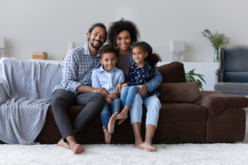 Happy perfect young Black family with two little sibling kids home portrait. Cheerful attractive...