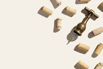 Background with wine corks and old bottle opener for white and red wine on beige pastel color with...