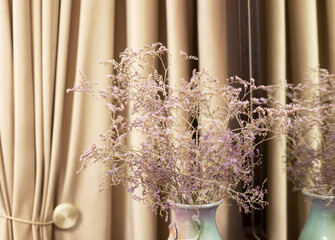 Still life. Vase with lilac flowers in a modern interior of a room in beige tones.
