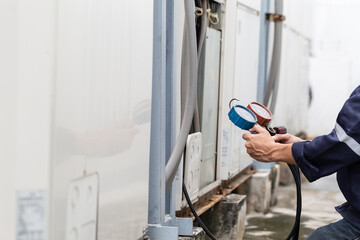 Technician is checking air conditioner ,measuring equipment for filling air conditioners.