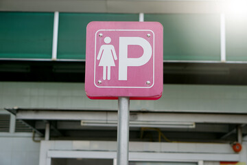 Traffic pink sign with symbol of lady and letter P at the public park. Concept : Parking place only...
