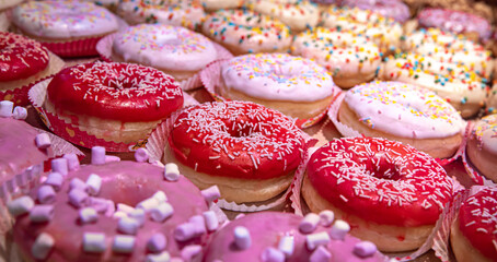 Close up of different donuts with sugar, frosted, glaze, and sprinkles.