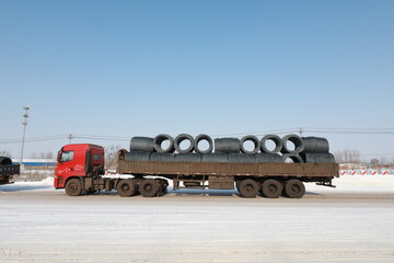 large freight vehicles waiting to pass outside the highway toll station in North China after heavy snow
