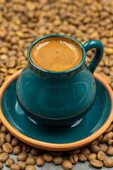 Turkish coffee in a rustic cup. Coffee beans background. close up