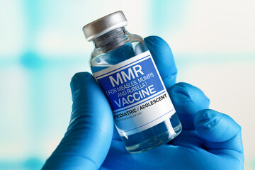 Doctor with vial of the doses vaccine for MMR Measless, Mumps and Rubella diseases. Medicine and health care concept. Vaccination for booster shot for MMR Measless, Mumps and Rubella diseases - obrazy, fototapety, plakaty
