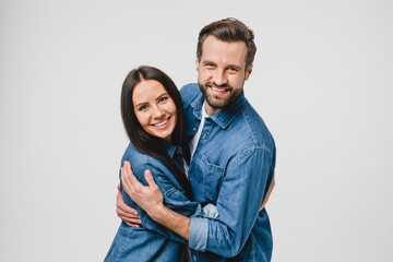 Happy young caucasian couple spouses wife and husband hugging embracing, spending time together looking at camera, sharing love and passion isolated in white background. Love and relationship concept