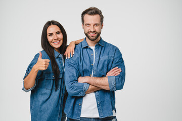 Smiling young caucasian friends boyfriend and girlfriend couple spouses looking at camera, embracing hugging showing thumb up isolated in white background. Love and relationship