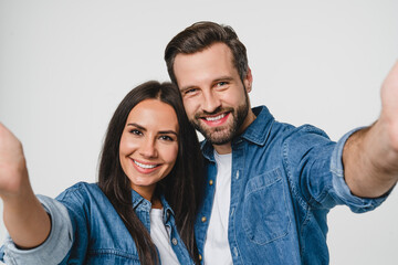 Young smiling caucasian couple boyfriend and girlfriend dating taking selfie photo together looking at camera, blogging vlogging for social media networks isolated in white background