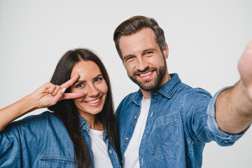 Closeup young smiling caucasian couple boyfriend and girlfriend spouses dating taking selfie photo together looking at camera, blogging vlogging for social media networks isolated in white background