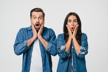 Shocked surprised amazed caucasian young couple spouses husband and wife looking at camera with...