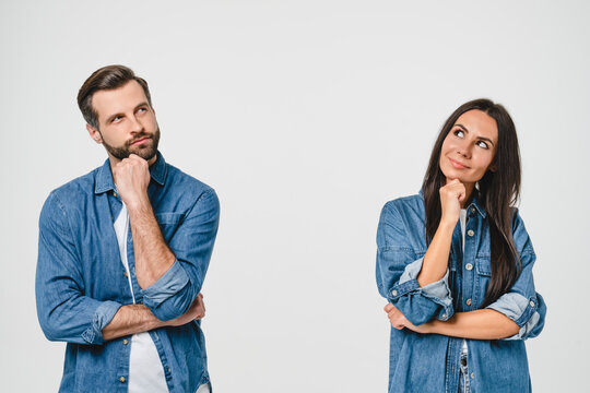 Thoughtful pensive caucasian young couple looking upwards for free space copyspace, thinking new ideas, planning for future together isolated in white background