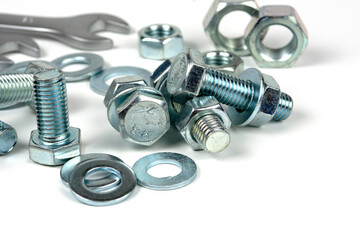 Several silver metal fixing bolts on a white background.Metal bolts and nuts. Wrenches for working with bolts and nuts. Close-up