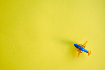 Yellow-blue toy plane on a yellow background. Takeoff! Travel concept. Place for text and advertising
