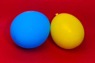 Ukraine balloons on red background. Support for Ukraine. Bright coloured blue and yellow balloons on red background. 