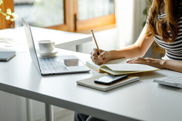 Close up of student woman study online with laptop teacher, happy young woman learn language listen lecture watch webinar write notes and laptop sit in a home, distant education