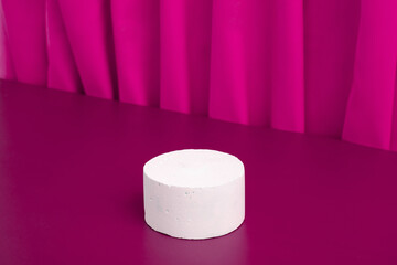Podiums or pedestal Mock-up for cosmetic production on a pink background with folds of fabric.