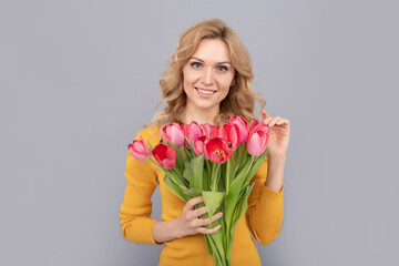 happy woman hold flowers for spring holiday on grey background