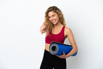 Young sport blonde woman going to yoga classes while holding a mat isolated on white background...