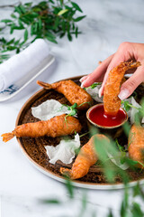 Japanese dish , battered deep fried seafood Tiger Prawns . Served with sauce