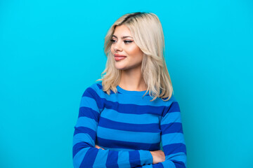 Young Russian woman isolated on blue background looking to the side