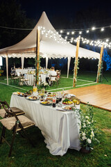 Wedding. Banquet. The chairs and round table for guests, served with cutlery. Evening time