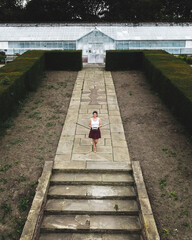 Woman standing in front of a glass pavilion in Temple Newsam, drone photo, Leeds, England, UK