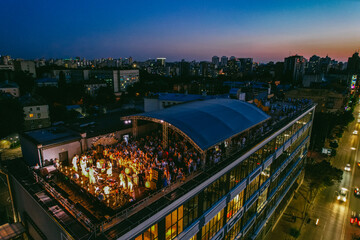 Aerial view of people enjoying outdoor party on the rooftop at night