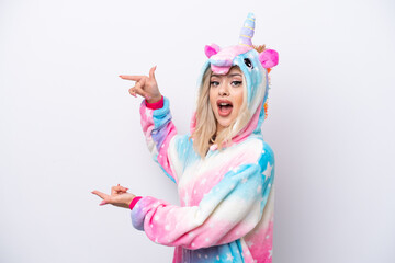 Young Russian woman with unicorn pajamas isolated on white background surprised and pointing side