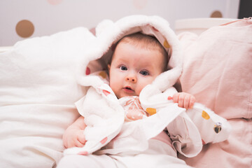 Baby girl, 5 month old, laying in bed, portrait of a toddler