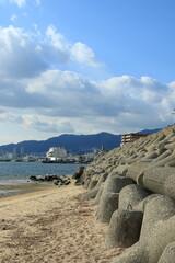 日本の都市風景　芦屋川河口付近から見た神戸の街並みとテトラポット