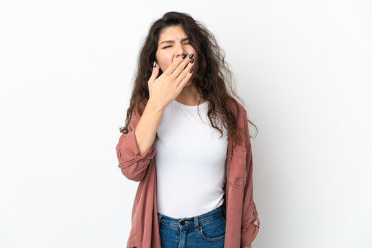 Teenager Russian girl isolated on white background yawning and covering wide open mouth with hand