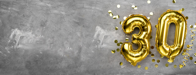 Yellow foil balloon number, number thirty on a concrete background. 30th birthday card. Anniversary concept. for anniversary, birthday, new year celebration. banner