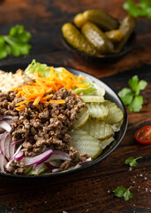 Cheeseburger, hamburger or burger keto salad with beef, fresh tomatoes, red onion, pickled gherkins, lettuce and home made sauce dressing