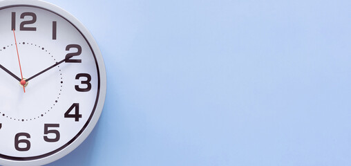 Clock on a blue background, the concept of time management, time planning. Web banner, free space.