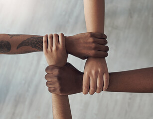 United we are strong. Cropped shot of a group of unrecognizable people holding each others wrists.