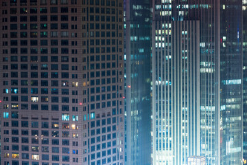Fototapeta na wymiar A city office building with lights on at night