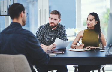 Sharing thoughts and ideas. Shot of a group of young designers having a discussion in an office.