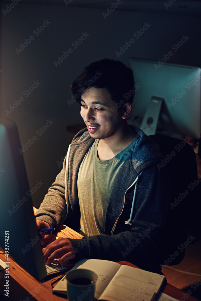 Poster Earning that extra buck on night shift. Cropped shot of a designer working on his computer on a night shift at work.