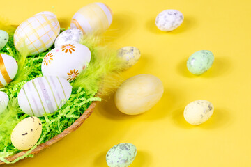 Fototapeta na wymiar Easter nest with eggs and feathers on a yellow background close-up. Minimal concept.