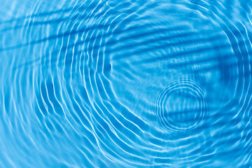 Shadow of tropical leaf palm tree, drop on blue water background. Top view, flat lay