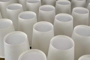 Row of white disposable eco friendly paper cup for coffee or hot beverage on dark backdrop. Selective focus. - 493775408