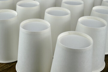 Row of white disposable eco friendly paper cup for coffee or hot beverage on dark backdrop. Selective focus. - 493775411