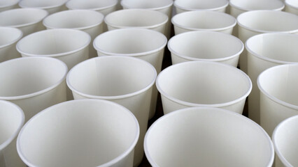 Row of white disposable eco friendly paper cup for coffee or hot beverage on dark backdrop. Selective focus. - 493775431