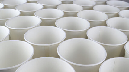 Row of white disposable eco friendly paper cup for coffee or hot beverage on dark backdrop. Selective focus. - 493775433