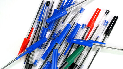 A lot of colorful ballpoint pens spinning on white screen in office or school. Top view. Selective focus. - 493775464