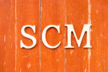 Alphabet letter in word SCM (Abbreviation of Supply chain management) on old red color wood plate background