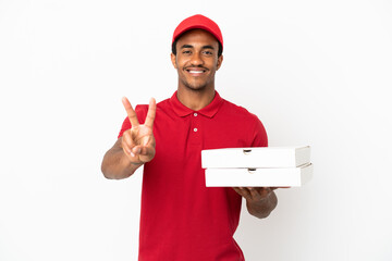 African American pizza delivery man picking up pizza boxes over isolated white wall smiling and...