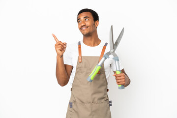 African American gardener man holding pruning shears over isolated white background pointing up a great idea
