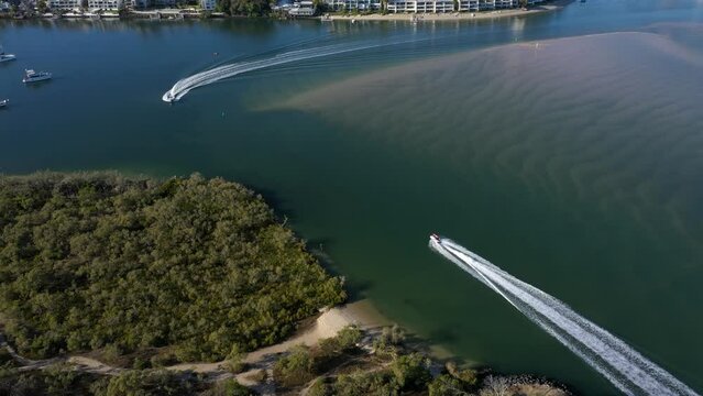 Boats on Noosa river. Aerial tilt reveals Noosa Heads resort town on clear, sunny day. Sunshine Coast, Queensland, Australia.