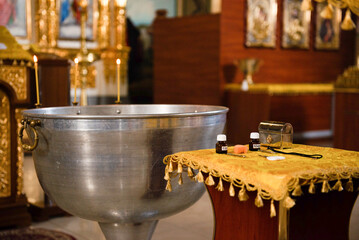 Christian composition view of church bowl and table with church items for baptism, bottles with ritual oil and casket